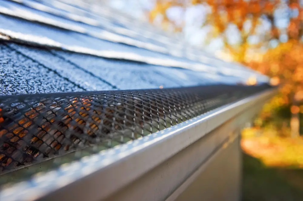 A close-up of a gutter featuring a mesh screen designed to prevent debris accumulation.