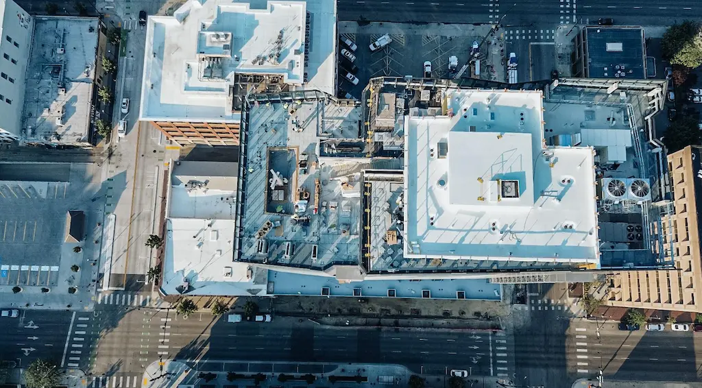 Aerial view of a building under construction, showcasing a commercial roof replacement in progress.